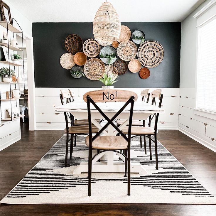 a dining room table and chairs in front of a wall with baskets hanging on it