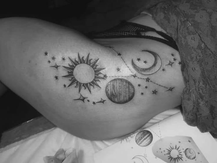 a woman's thigh with tattoos on it and the sun, moon and stars