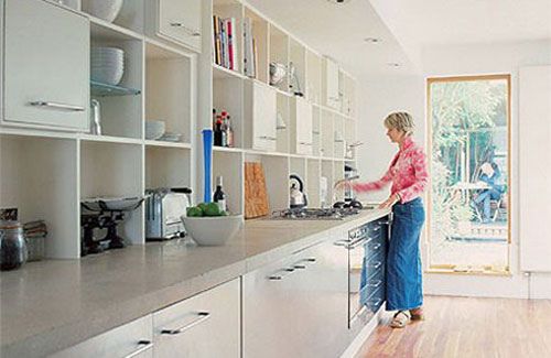 a woman standing at the counter in a kitchen