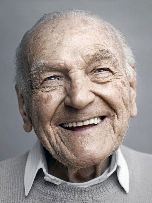 an old man smiling and wearing a tie