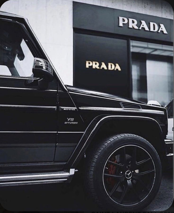 a black jeep parked in front of a prada store