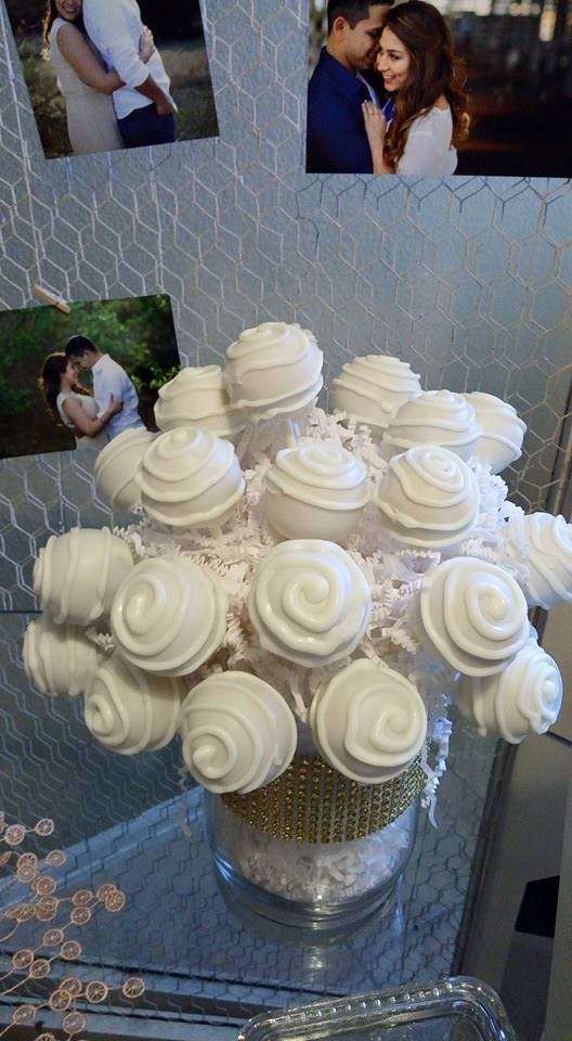 a vase filled with white frosted cupcakes