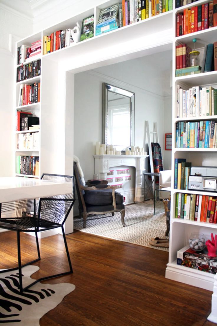 a living room filled with lots of books and furniture