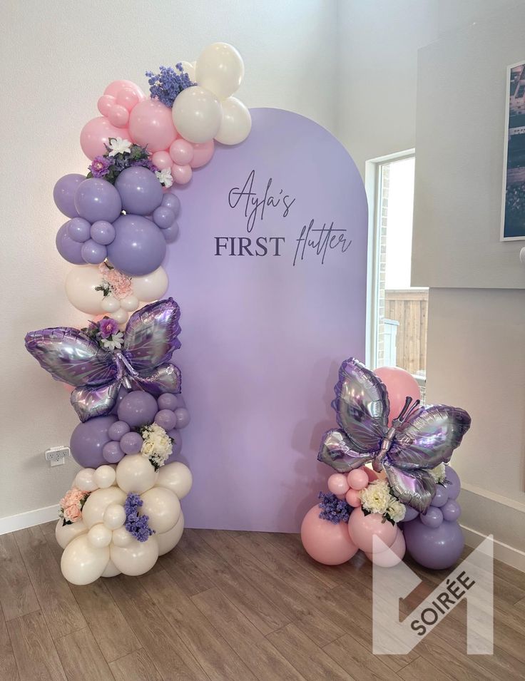 balloon arch with flowers and butterflies for first birthday party at home or baby's room