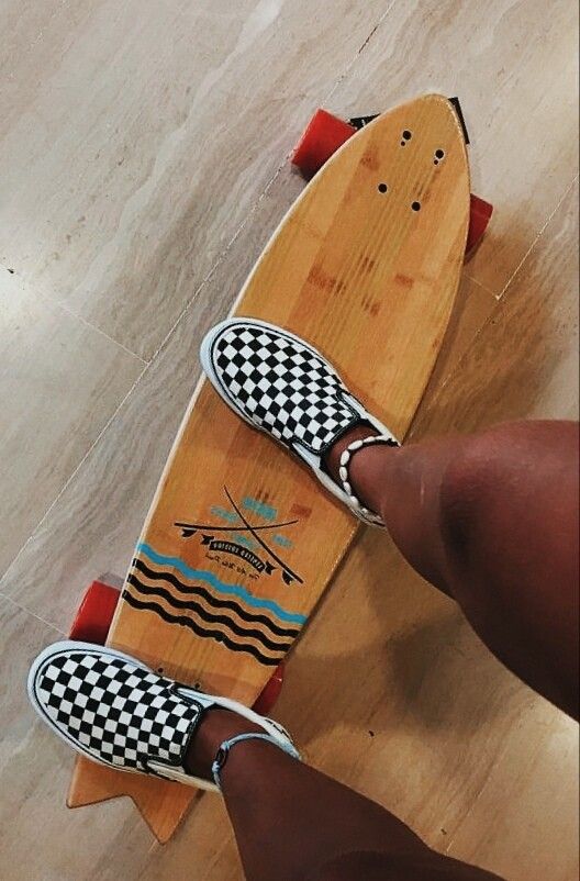 a person is standing on a skateboard with checkered boards and red wheels that are attached to the board