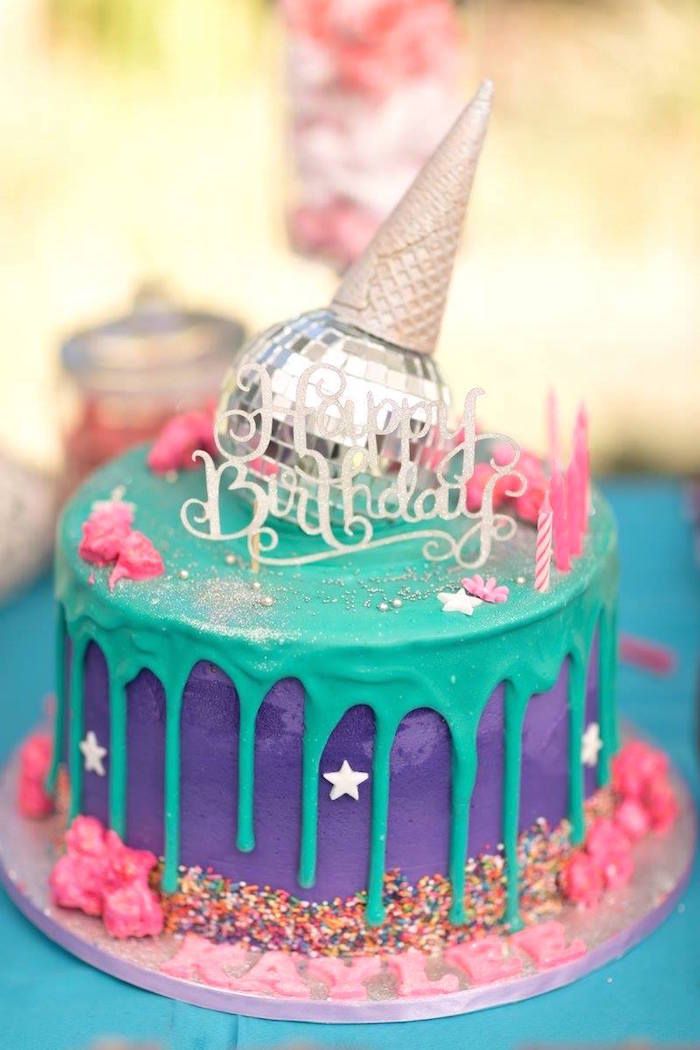 a birthday cake decorated with the eiffel tower on top and sprinkles