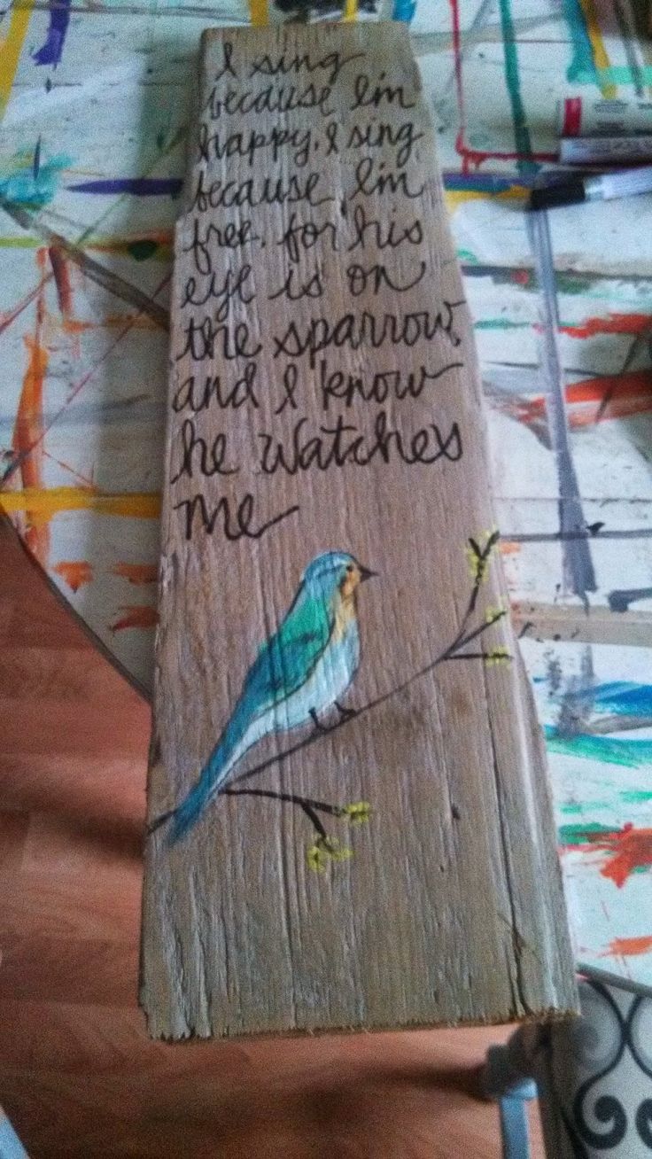 a piece of wood that has writing on it and a bird painted on the side