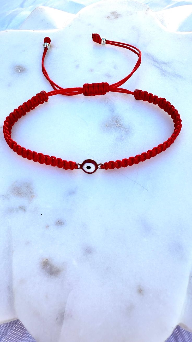 Embrace protection and style with our handcrafted Red Thread Bracelet featuring a stunning Evil Eye charm. This bracelet is designed to ward off negative energies and bring you peace of mind. The vibrant red thread symbolizes strength and vitality, making it a perfect accessory for everyday wear. Crafted with care, the Evil Eye charm is made from durable, water-resistant metal, ensuring that you can wear it all day, every day, without worry. Whether you're at the beach, working out, or enjoying Adjustable Red Beaded Bracelets For Meditation, Traditional Red Bracelets For Meditation, Red Spiritual Bracelet For Good Luck, Spiritual Red Bracelet For Good Luck, Red Round Bracelets For Meditation, Red Spiritual Friendship Bracelets For Good Luck, Adjustable Red Hand Wrapped Friendship Bracelets, Red Spiritual Bracelets For Friendship, Traditional Hand Wrapped Red Bracelets