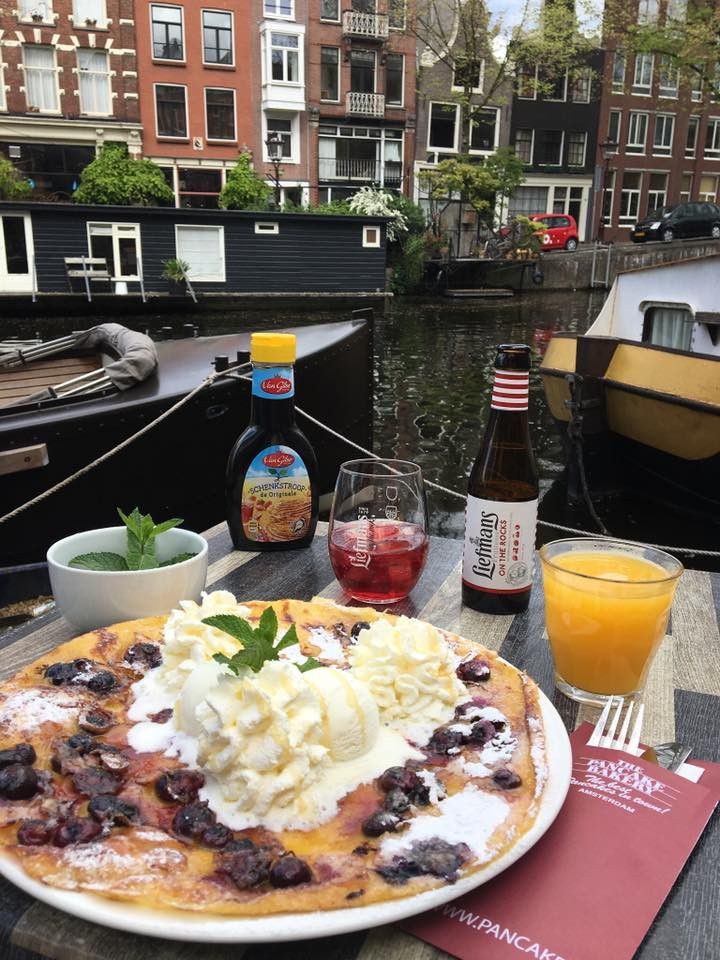 a plate with food and drinks sitting on a table next to some boats in the water