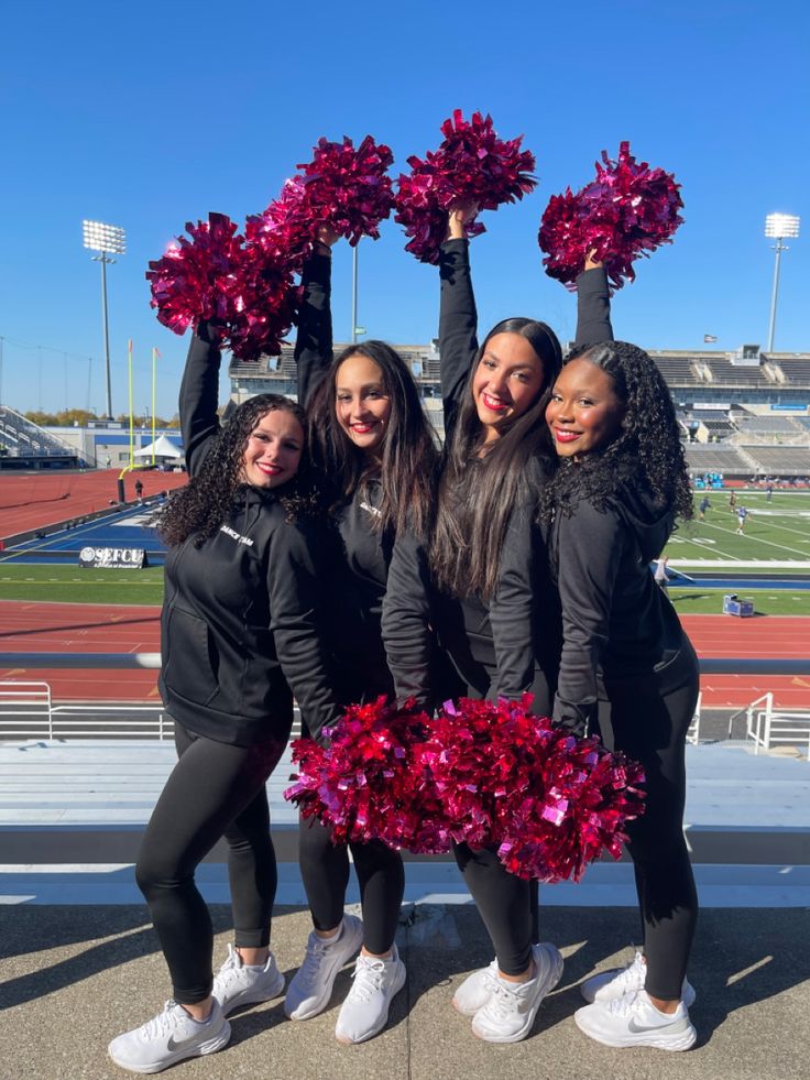 the cheerleaders are posing with their pom - poms in front of an empty bleachers