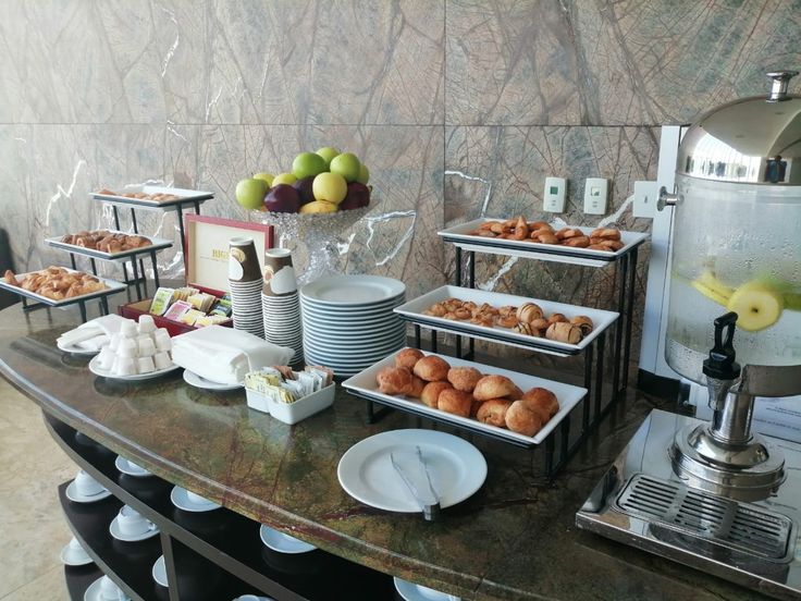 an assortment of pastries and desserts are on display at a buffet table in a hotel room