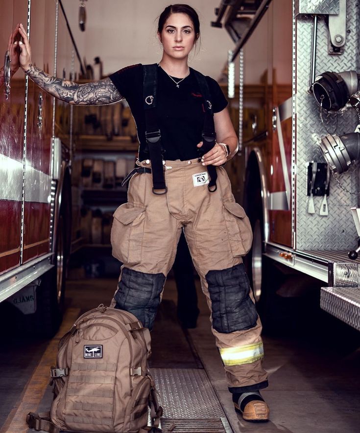 a woman standing in front of a fire truck with her back pack on the ground