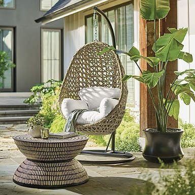 a wicker hanging egg chair on a patio