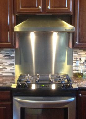 a stove top oven sitting inside of a kitchen next to wooden cupboards and counter tops