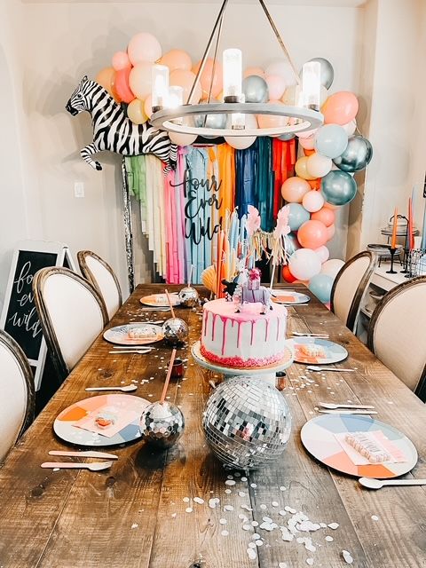 a birthday party with balloons, cake and decorations