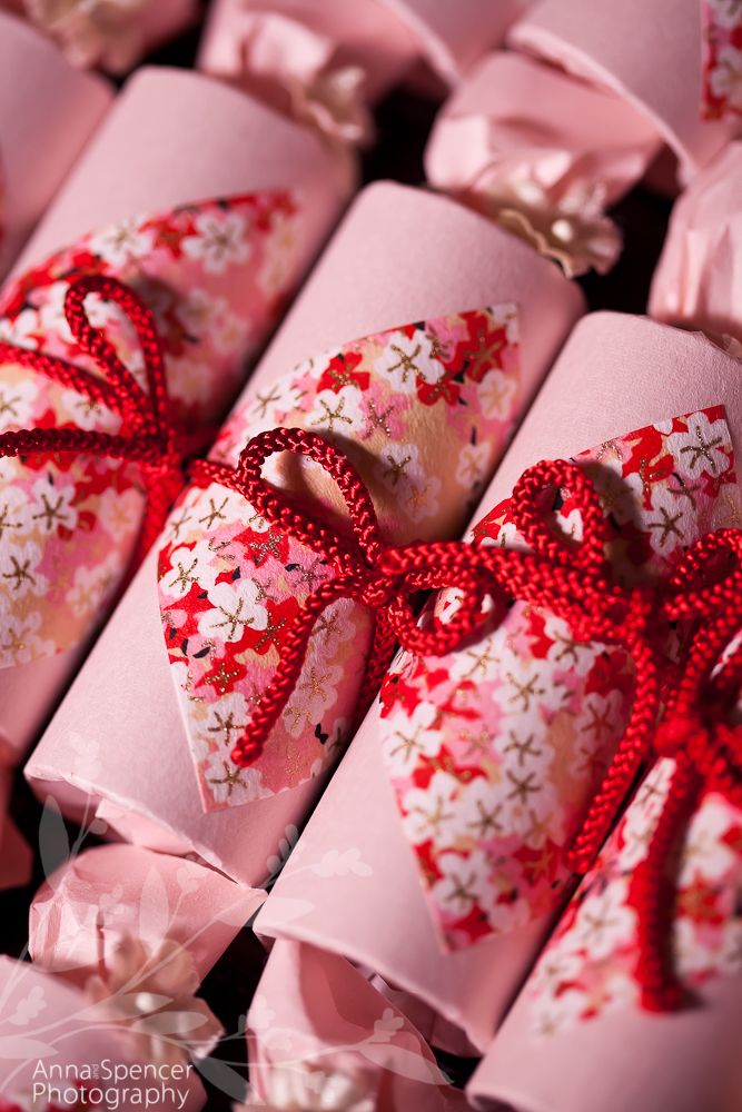 pink wrapped presents with red ribbons and bows on them, all lined up next to each other