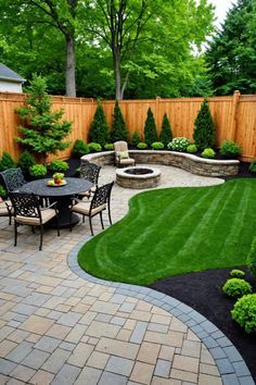 an outdoor patio and landscaping area with green grass, shrubs, and trees in the background