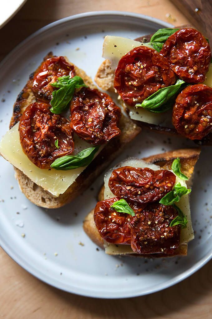 four slices of bread topped with tomatoes and cheese