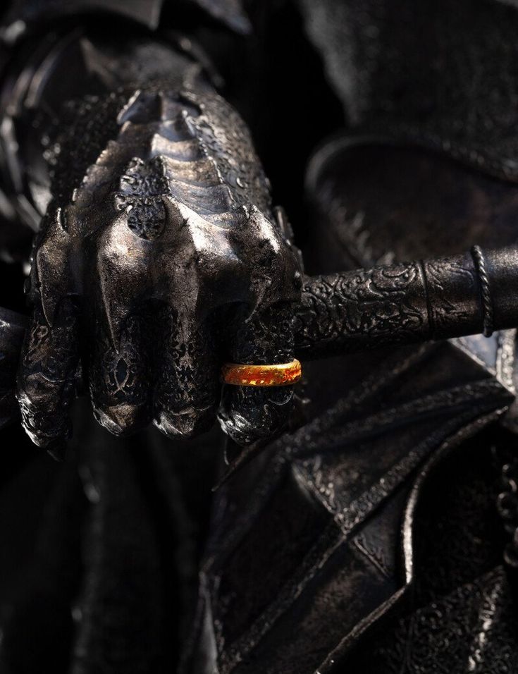 a close up of a statue holding an orange object in it's right hand