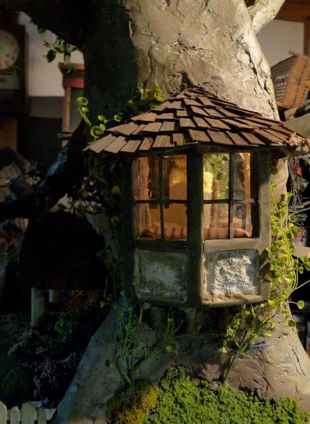 a bird house made out of rocks and wood with moss growing on it's roof