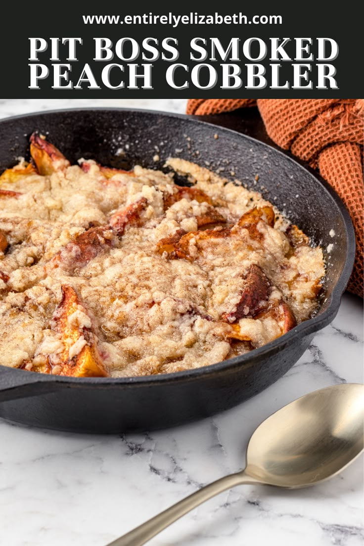 a skillet filled with peach cobbler on top of a marble counter