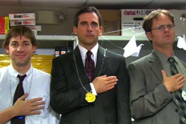 three men in suits standing next to each other with their hands on their chests