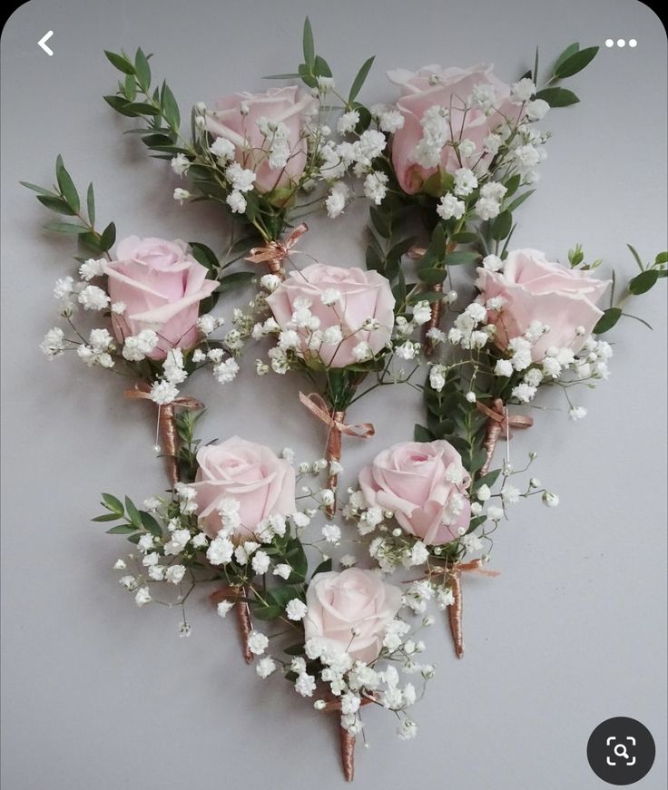 pink roses and baby's breath are arranged in a heart shape