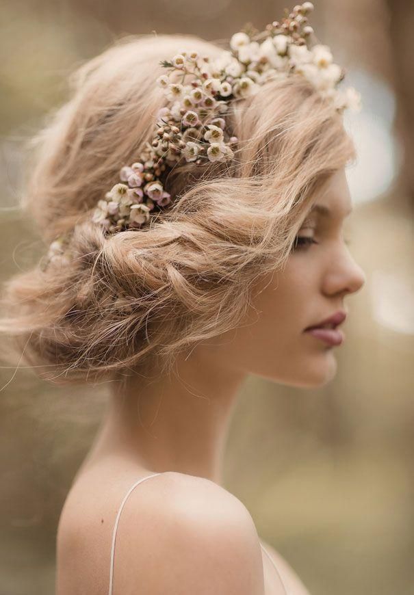 a woman with pink hair and flowers in her hair is wearing a headpiece made out of dried flowers