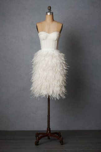 a dress on a mannequin with white feathers