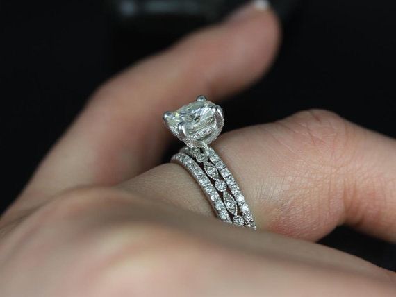 a close up of a person's hand holding a diamond ring