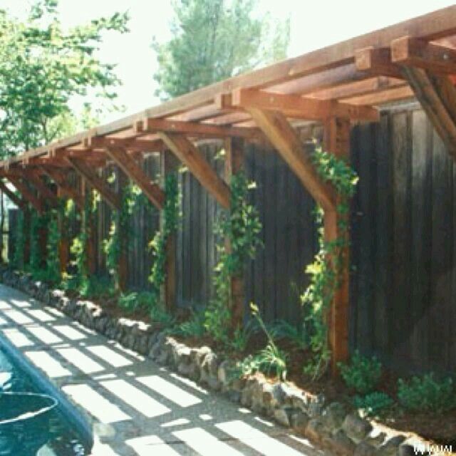 a row of wooden pergols with vines growing on the top and bottom of them