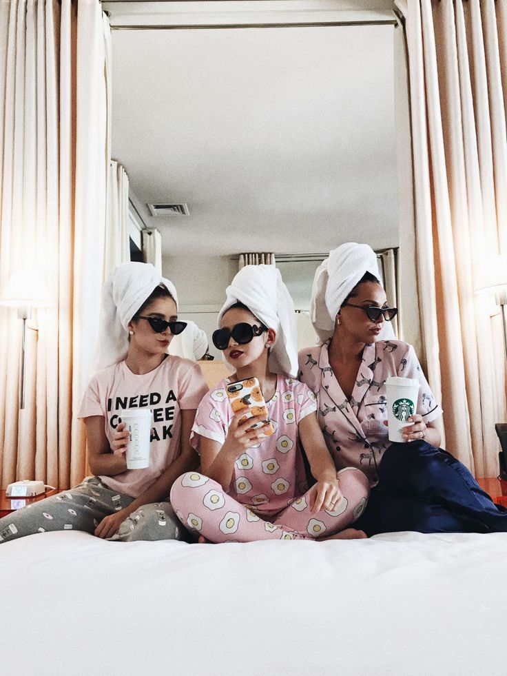 two women in matching pajamas sitting on a bed