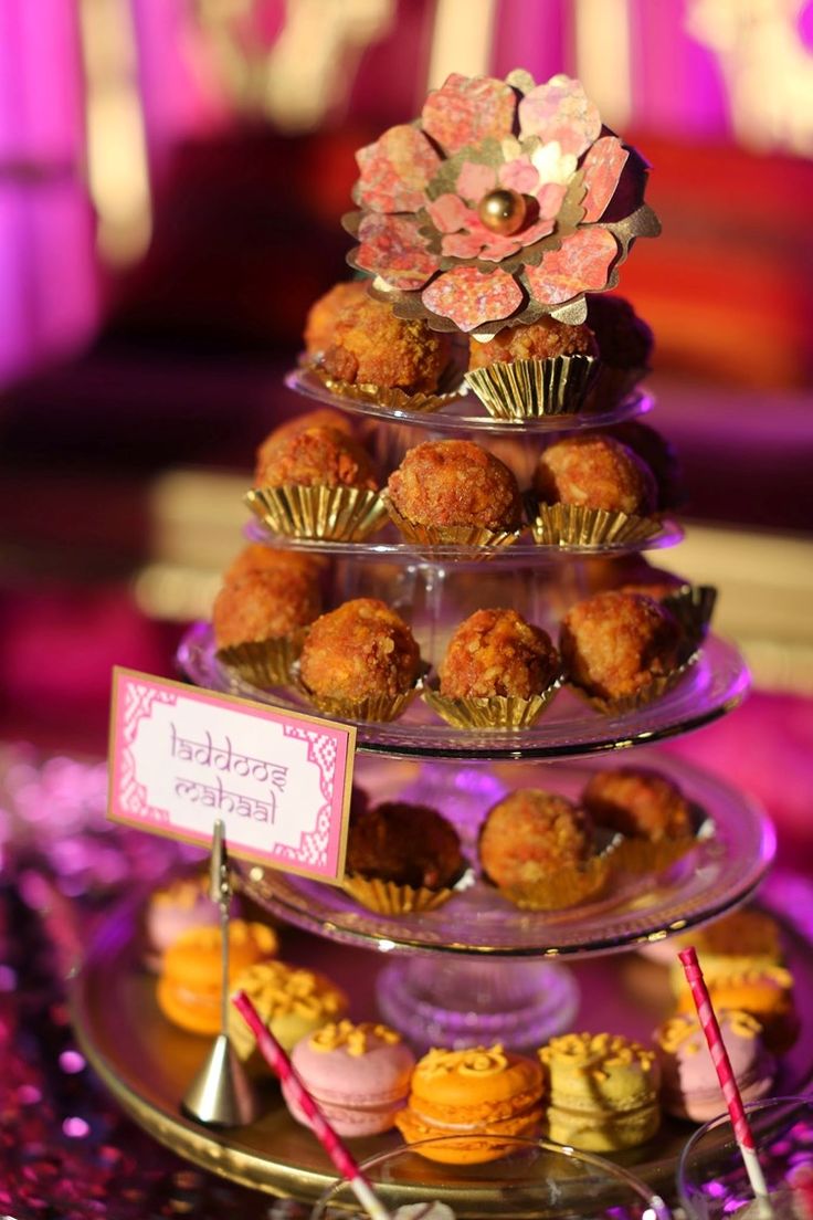 three tiered trays filled with cupcakes and muffins on top of each other