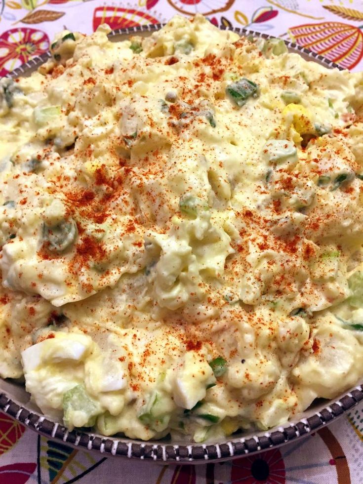 a bowl filled with food sitting on top of a colorful table cloth covered tablecloth