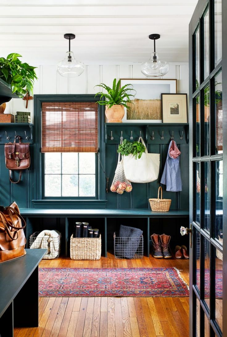 an entryway with green walls and wooden flooring, potted plants on the wall