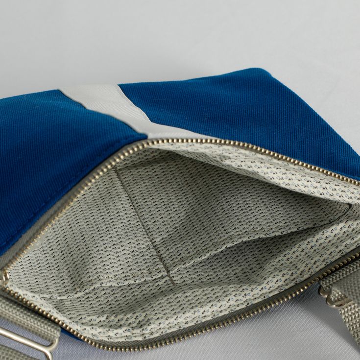 Our crossbody pouch now comes in a stunning blue and white pattern! With a slim profile that expands to hold your keys, phone, card holder and more, this pouch is classic and functional. Upcycled like all of our bags, this crossbody pouch was handcrafted by a woman in recovery and was uniquely designed from a pair of pants worn by the West Point Concert/Marching Band and the Hellcats field music group. Purchase this upcycled, crossbody pouch and create possibilities for women on our team to sust Blue Travel Pouch For Mobile Phone, Blue Mobile Phone Pouch For Travel, Blue Mobile Phone Travel Pouch, Blue Crossbody Phone Bag For Everyday, Blue Rectangular Phone Bag For Everyday Use, Blue Phone Bag With Cell Phone Pocket For On-the-go, Blue Pouch Phone Bag For Gift, Blue Shoulder Bag With Cell Phone Pocket, Blue Shoulder Bag With Cell Phone Pocket For Gift