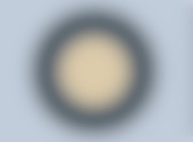 a blurry image of a circular object in grey and white with light blue background