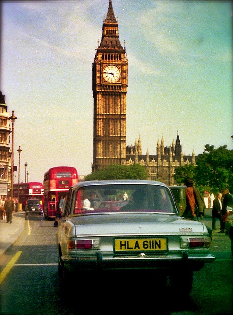 the big ben clock tower towering over the city of london as seen from across the street