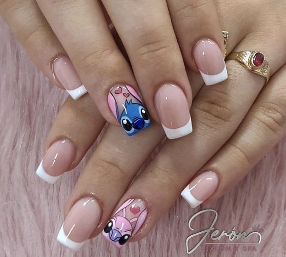 a woman's hand with french manies decorated with cartoon character nail art designs