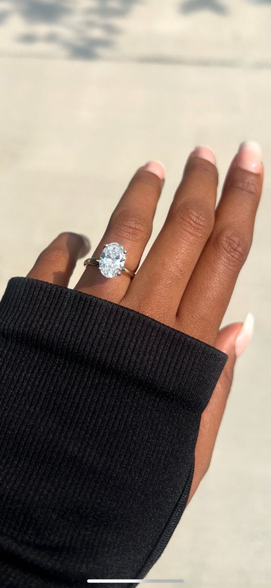 a woman's hand with a diamond ring on it