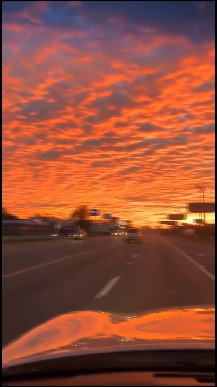 the sun is setting over an empty highway