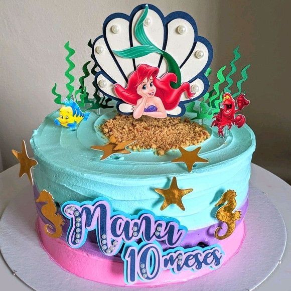 a birthday cake decorated with an ariel the mermaid theme