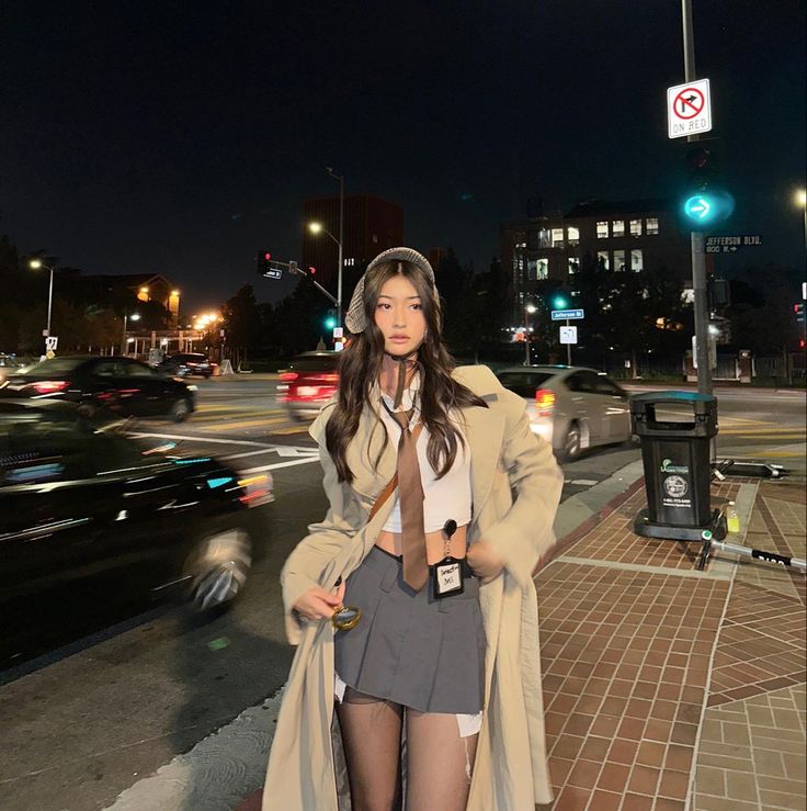 a woman is standing on the street at night