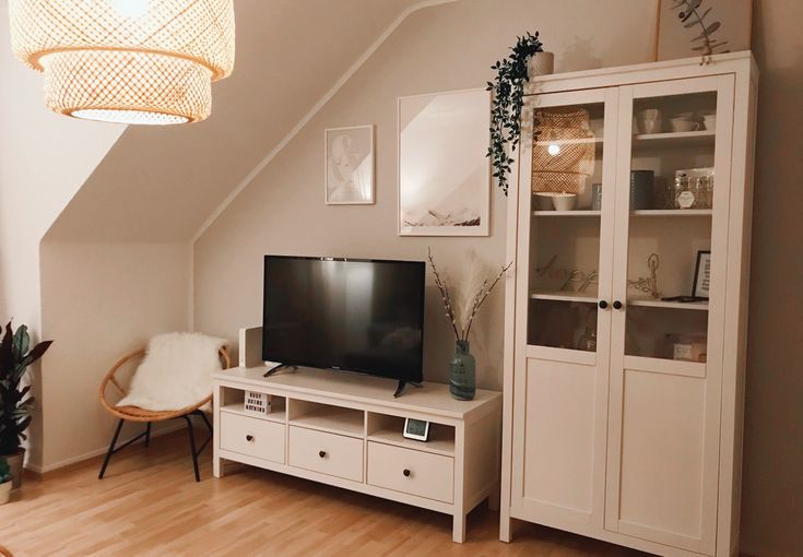 a flat screen tv sitting on top of a white entertainment center in a living room