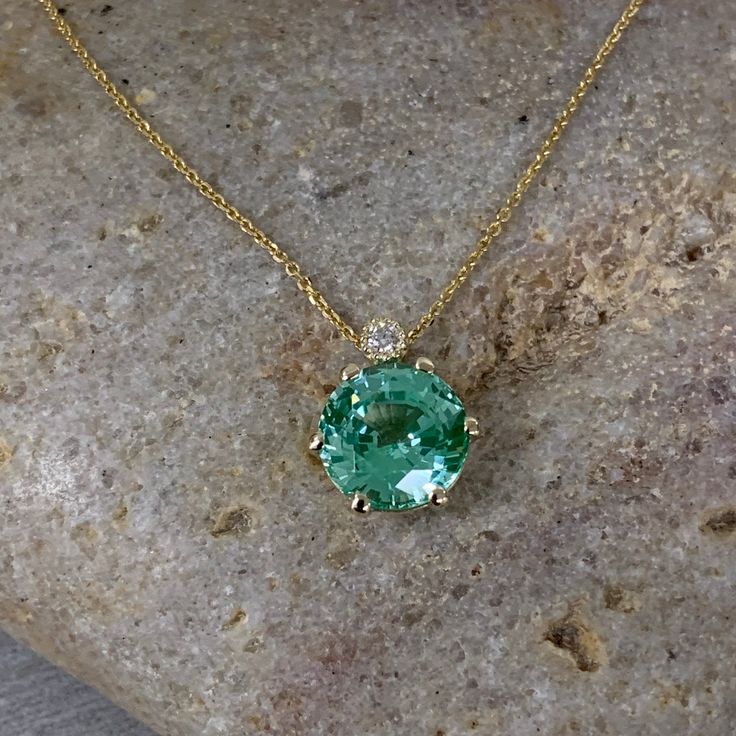 "The pendant pictured is lab created green paraiba #6892. We feature the finest quality lab grown gem stones in the world. The properties of lab-grown are physically, chemically and visually identical to natural, just grown in a lab setting. -Approximate total carat weight: 2.74ctw. diamond equivalent -Stone Size: approx. 2.70ct. diamond equivalent -Stone Shape: round 9mm -Gem Type: lab created Paraiba -Stone Clarity: VS2 -Stone Color: Green (light mint green) -Moh's Scale: 7.5 - 8 hardness -Acc Green Brilliant Cut Necklace For May Birthstone, Green Gemstone Round Cut Necklace, Green Gemstone Necklace With Round Cut, Gia Certified Green Necklace For Formal Occasions, Formal Green Gia Certified Necklace, Green Emerald Necklace With Brilliant Cut For May Birthstone, Green Oval Diamond Cut Necklace, Green Pendant Necklace With Prong Setting, Green Necklaces With Prong Setting For May Birthstone