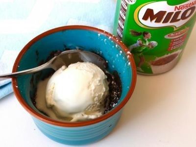 an ice cream in a blue cup next to a can of milk