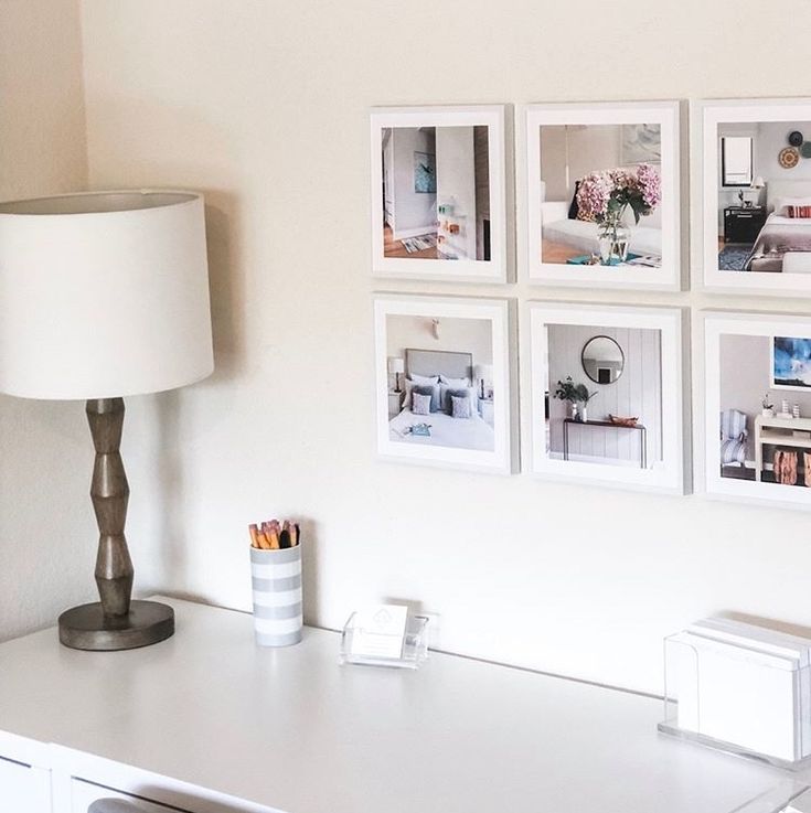 a white desk topped with pictures and a lamp