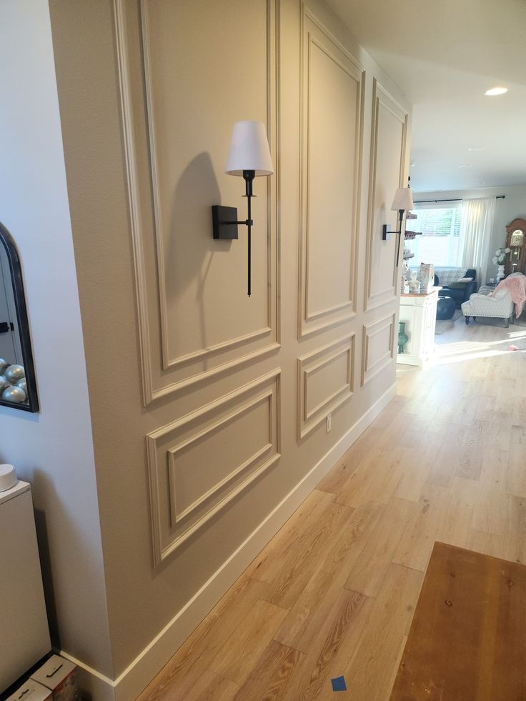 an empty room with white walls and wood flooring is seen in this image from the hallway to the living room