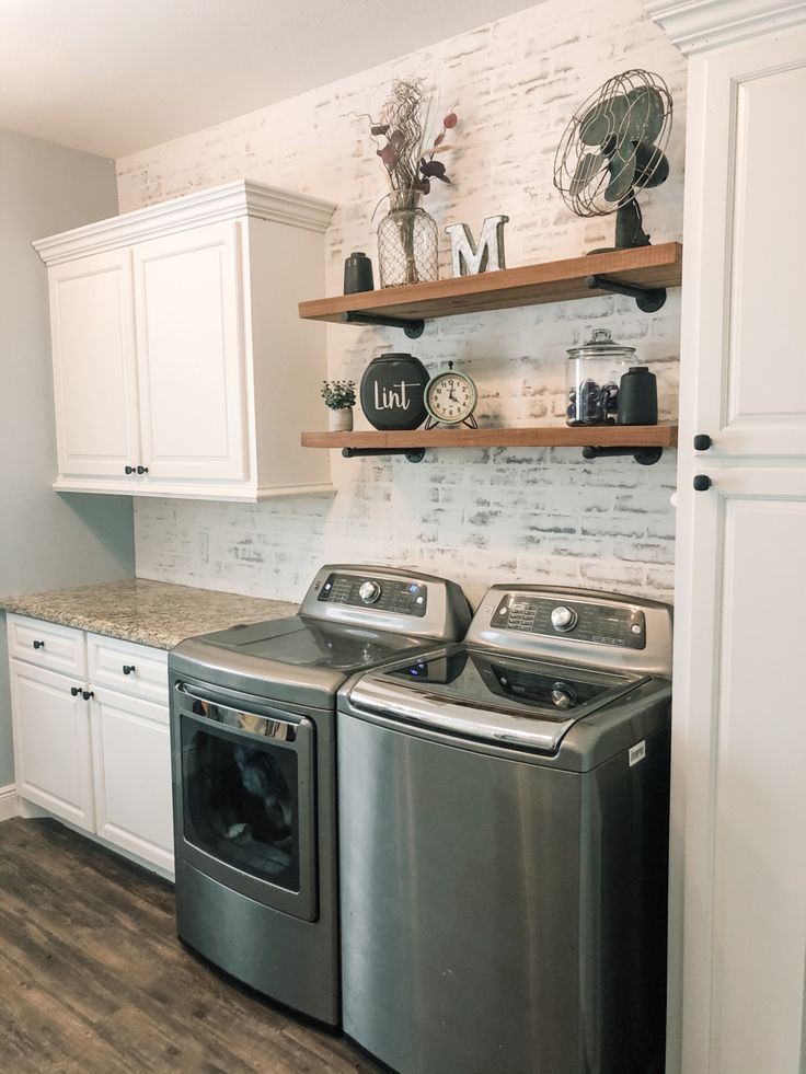 a washer and dryer in a kitchen with white cabinets