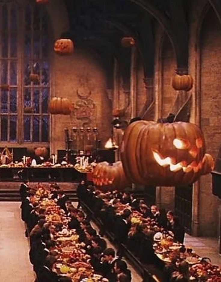 a large hall filled with lots of tables covered in pumpkins and other decorations for halloween